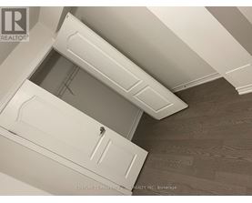 A white door with a handle is in the middle of a room with a wooden floor.