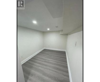 A room with a grey carpet and white walls.