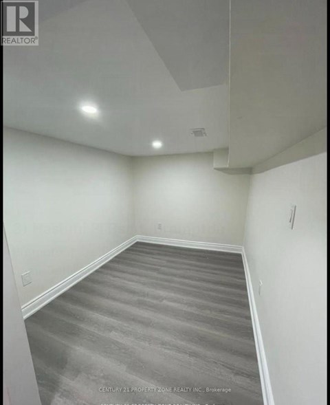 A room with a grey carpet and white walls.