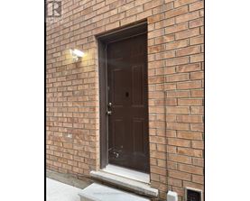 A brown door is on a brick wall.