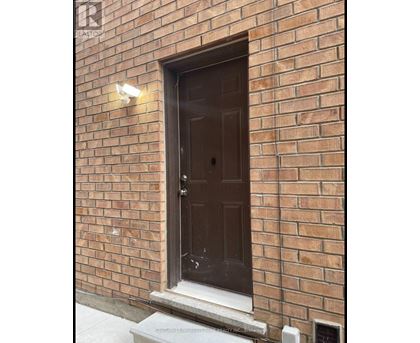 A brown door is on a brick wall.
