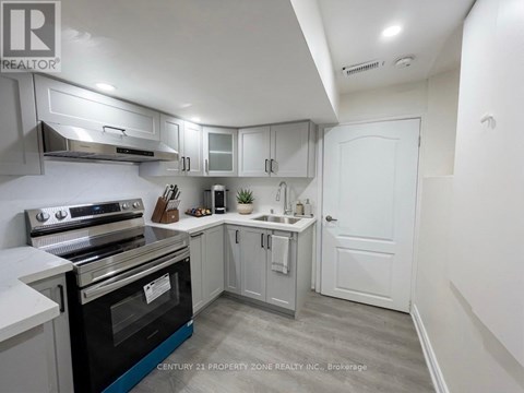 A kitchen with a stove top oven and a sink.