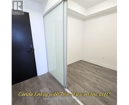 A room with a condo entry and a den area on the left.