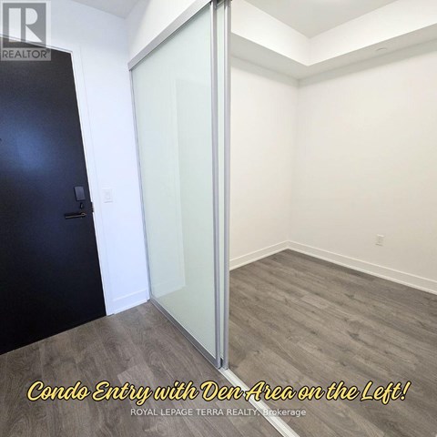 A room with a condo entry and a den area on the left.