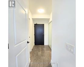 A hallway with a black door and white walls.