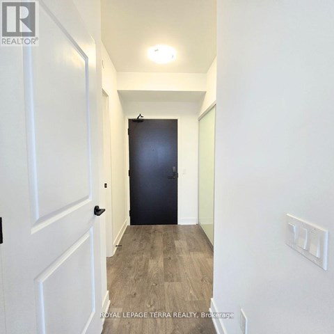 A hallway with a black door and white walls.