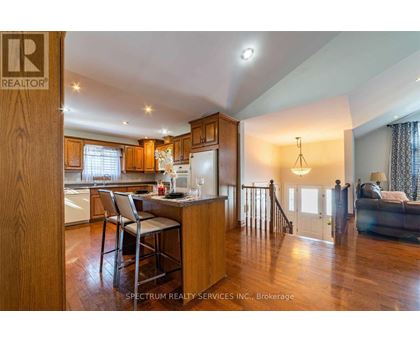 A modern kitchen with wooden cabinets and a dining table.