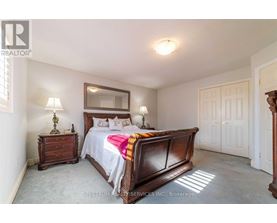 A bedroom with a large bed and a wooden dresser.