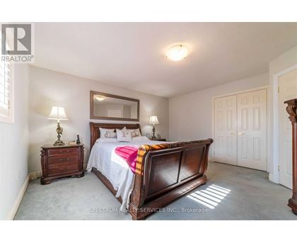 A bedroom with a large bed and a wooden dresser.