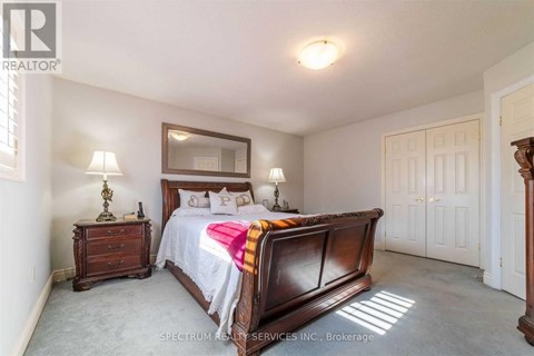 A bedroom with a large bed and a wooden dresser.