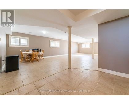 A spacious room with a dining table and chairs.