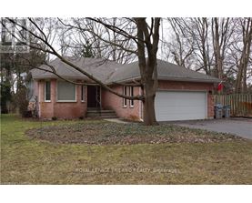 A house with a garage and a tree in front.
