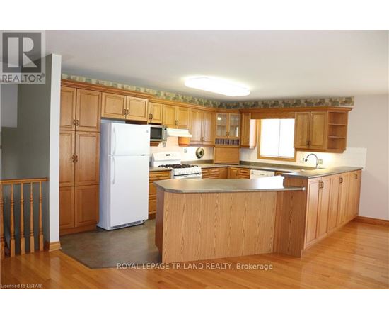 A kitchen with wooden cabinets and a white refrigerator.