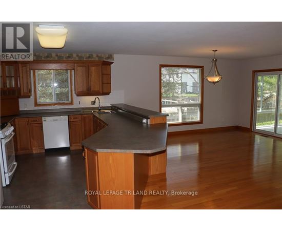 A kitchen with wooden cabinets and a large island.