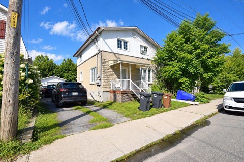 A house with a car parked in front of it.