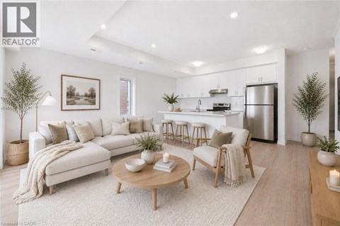 A modern living room with a white sofa, wooden coffee table, and a kitchen in the background.