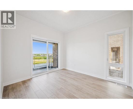A room with a sliding glass door leading to a balcony.