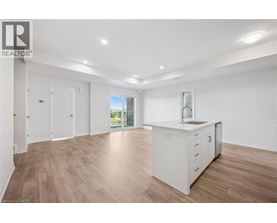 A spacious room with wooden flooring and white walls.