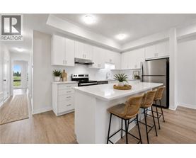 A modern kitchen with white cabinets and a central island.