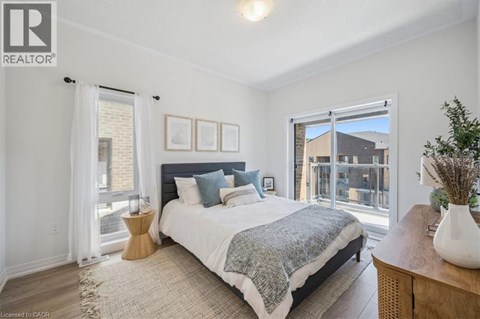 A bedroom with a large bed and a view of a balcony.