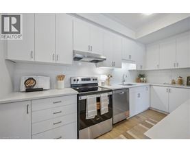 A modern kitchen with white cabinets and stainless steel appliances.