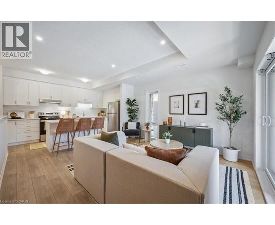A well-lit, modern living room with a kitchen in the background.