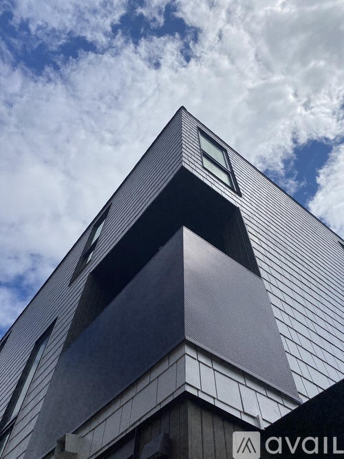 A modern building with a triangular facade and a sign that reads "AVAIL".