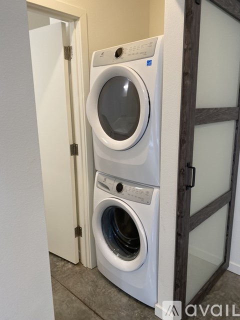 A white front load washing machine in a laundry room.