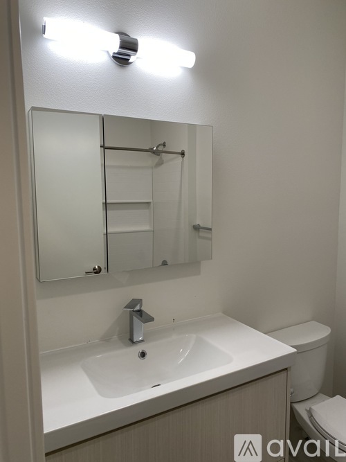 A bathroom with a sink, mirror, and toilet.
