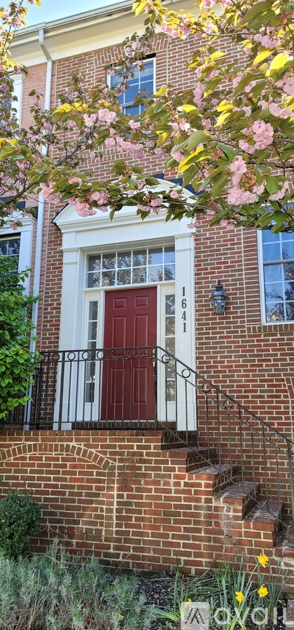A red door is on the front of a brick building.