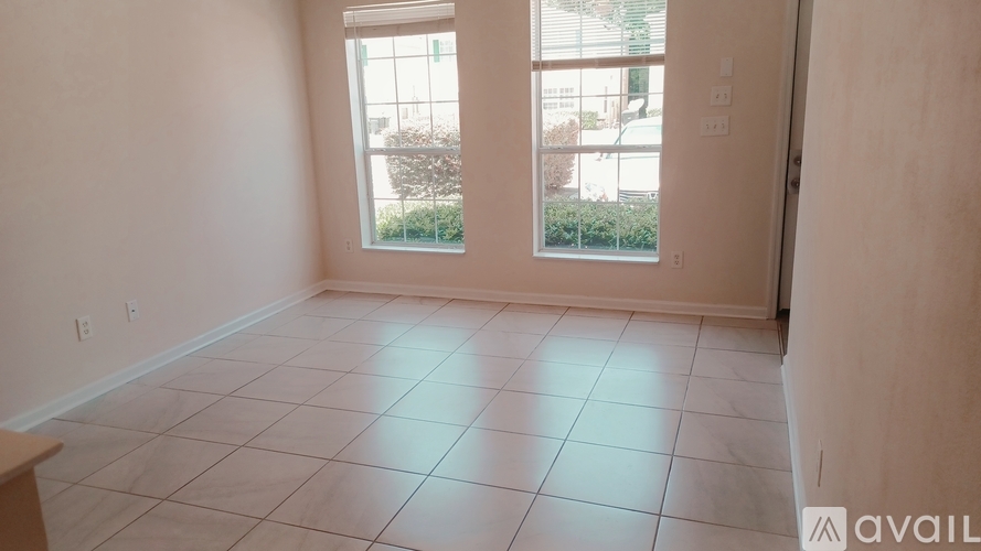 A room with a tiled floor and a window overlooking a street.