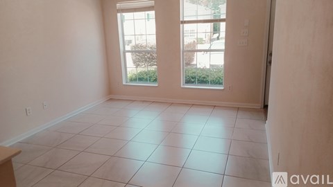 A room with a tiled floor and a window overlooking a street.