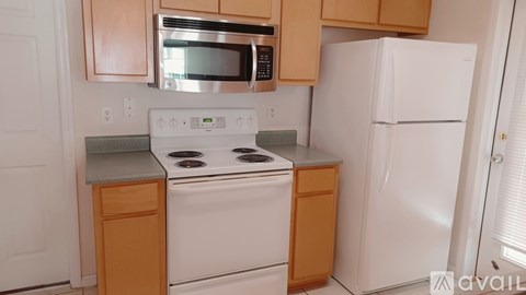 A kitchen with a white stove and a white refrigerator.