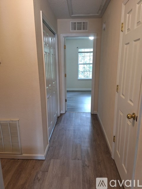 A hallway with wood floors and white walls.