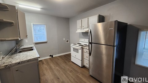 A kitchen with a stainless steel refrigerator and white appliances.