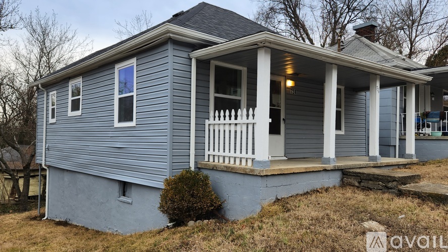 A small house with a porch and a single window.