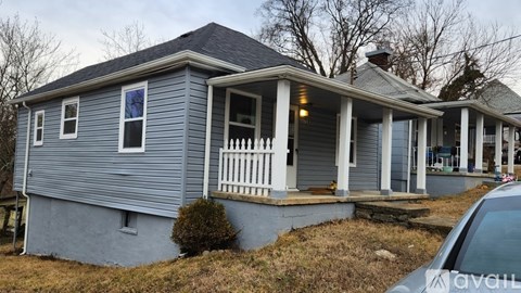 A house with a porch and a car parked in front.
