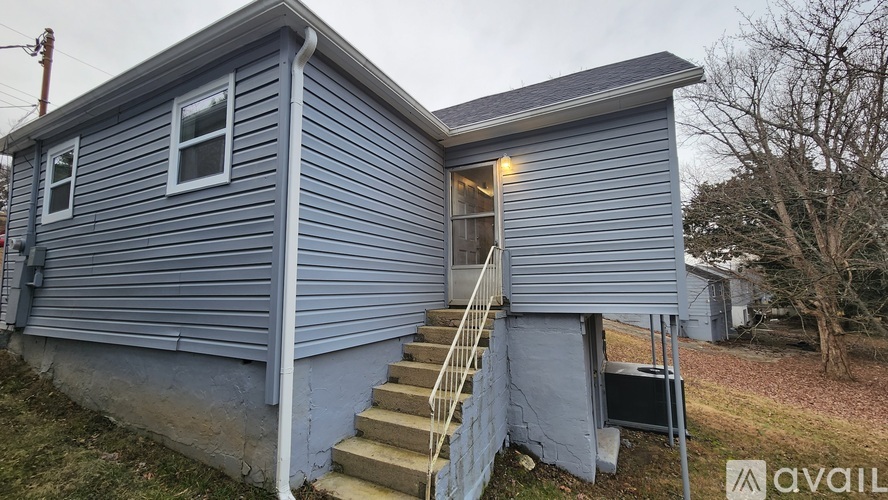 A house with a blue exterior and a staircase leading to the second floor.