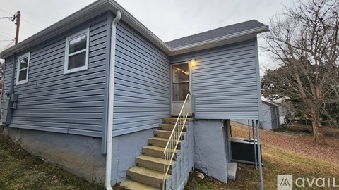 A house with a blue exterior and a staircase leading to the second floor.