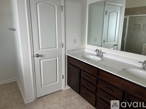 A bathroom with a white door and a sink with a mirror above it.