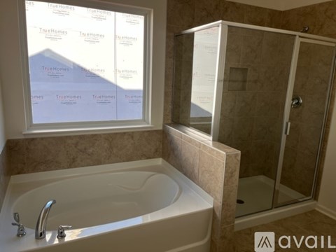 A bathroom with a tub and a shower stall.