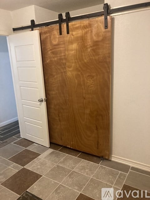 A wooden door is closed and has a black handle.