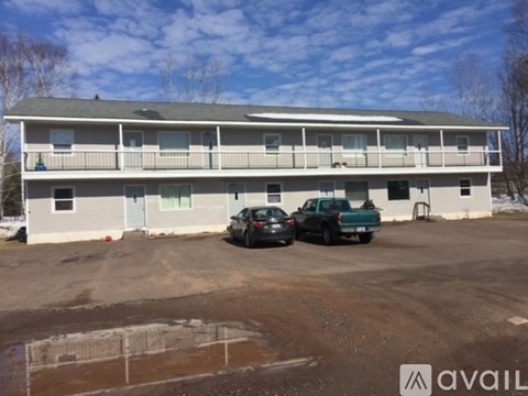 A two-story building with a parking lot in front.