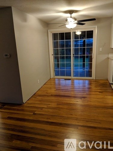 A room with wooden floors and a ceiling fan.