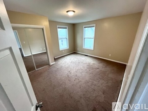 A room with a carpeted floor and a window.