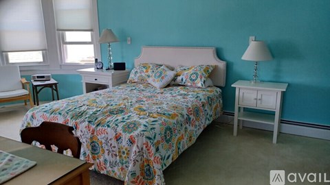 A bedroom with a bed, nightstands, and a lamp.