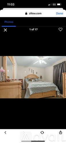 A bedroom with a bed, dresser, and mirror.