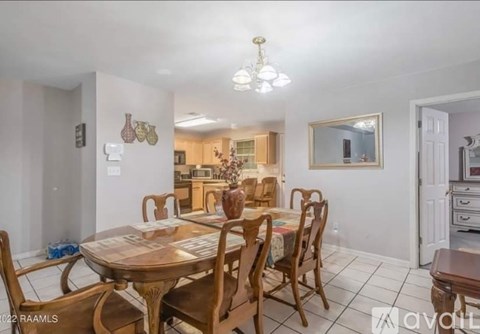 A dining room with a wooden table and chairs.