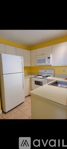 A kitchen with a white refrigerator and a white microwave above a stove.