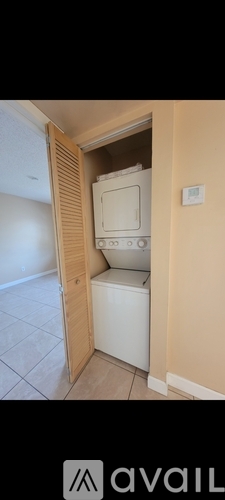 A white washing machine is tucked into a small space in a home.